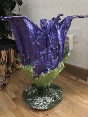 Eine aus Gips hergestellte, bemalte violette Blume.